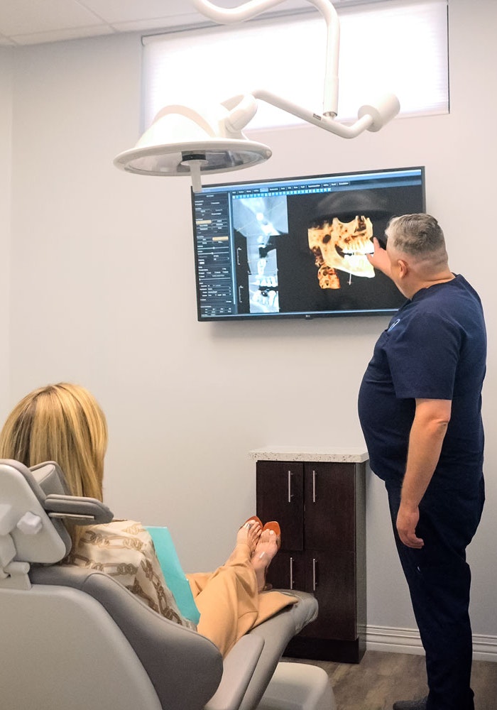 Dr. Pat Gaus reviewing 3D dental scan with patient in exam room