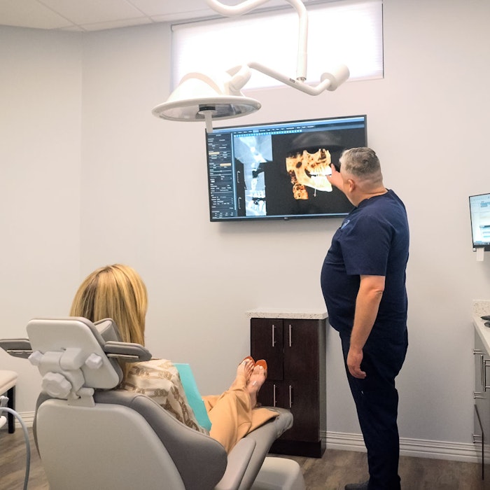 Dr. Pat Gaus reviewing 3D dental scan with patient in exam room