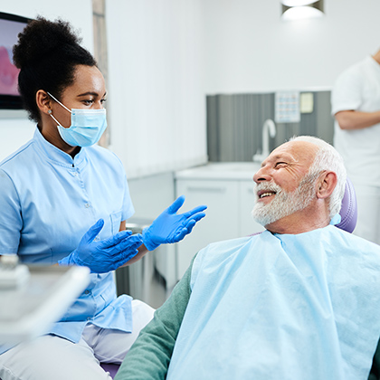 man speaking to dentist chairside