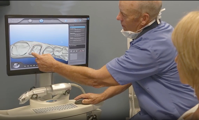 Dentist looking at dental scan with patient