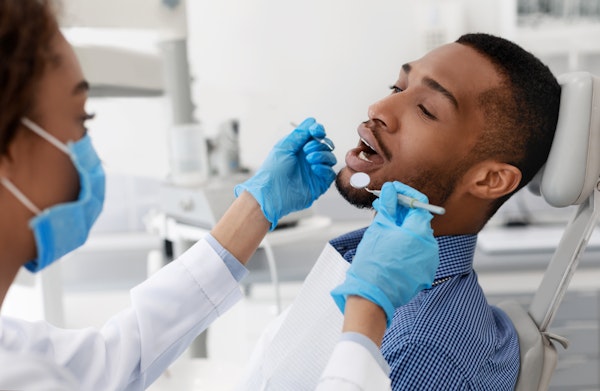 Dentist examining an extraction patient's mouth
