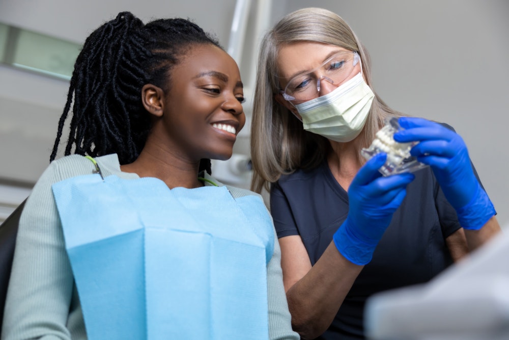 dentist showing patient a model of teeth