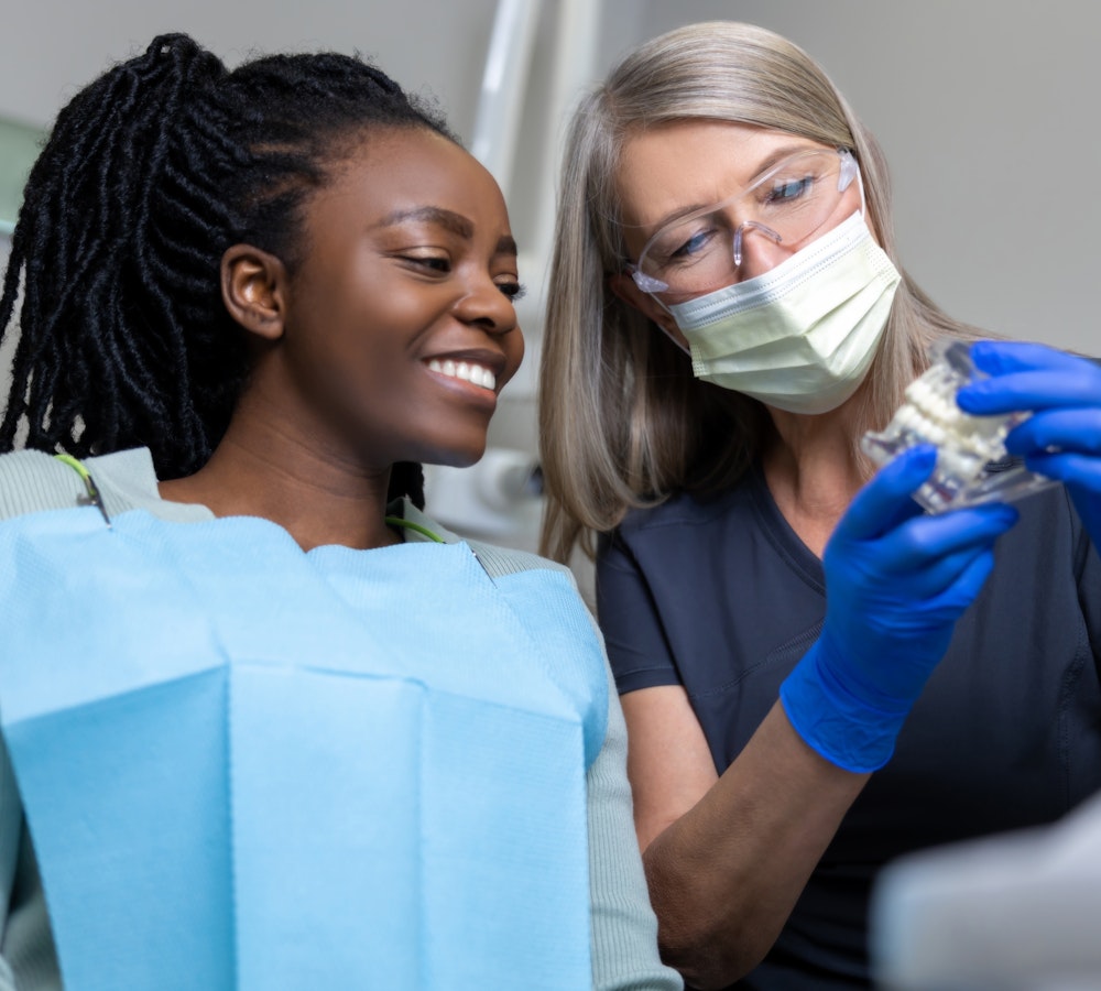 dentist showing patient a model of teeth