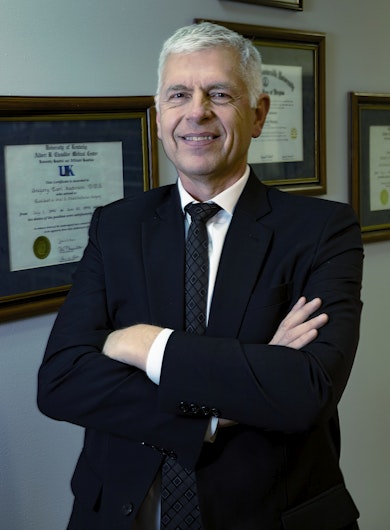 Doctor Anderson standing in front of diplomas