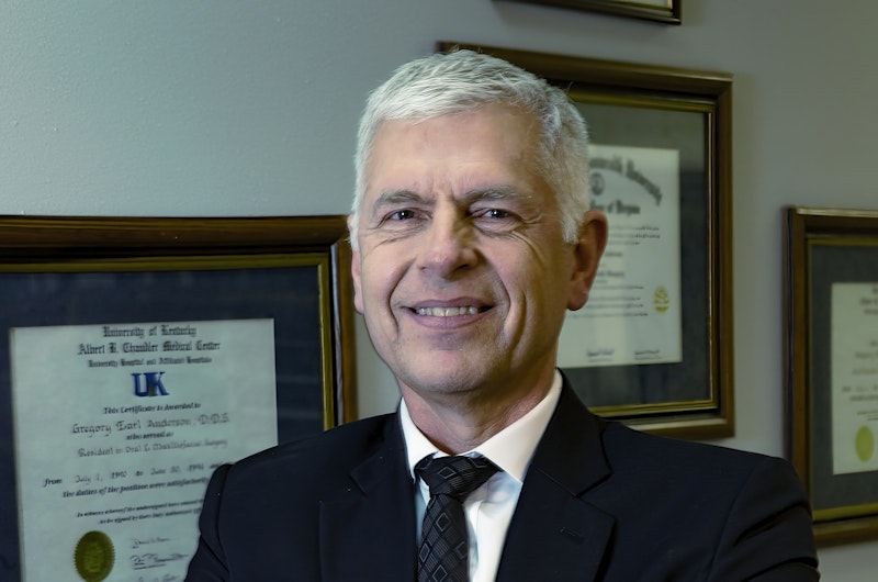 Doctor Anderson standing in front of diplomas