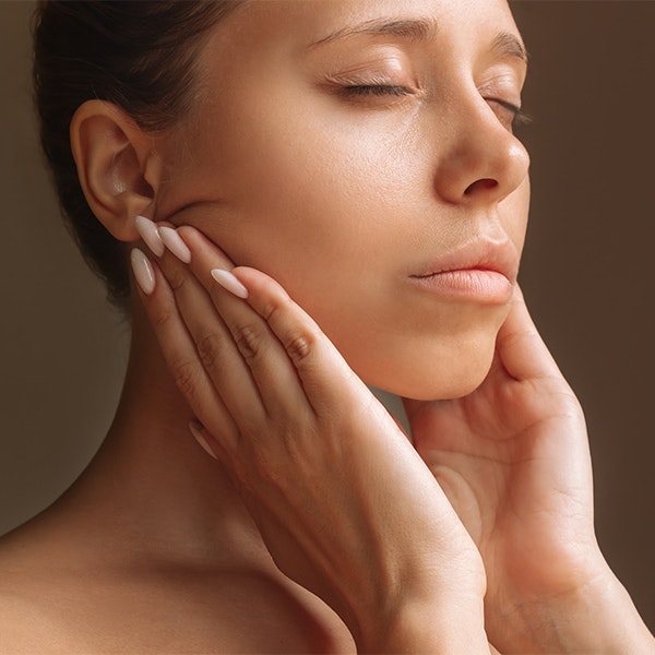 A woman performing mouth stretches