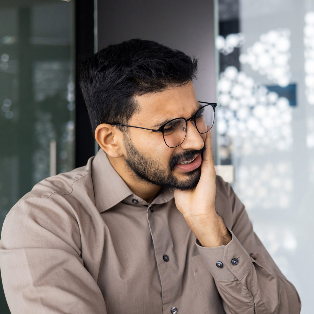 woman holding her jaw in pain