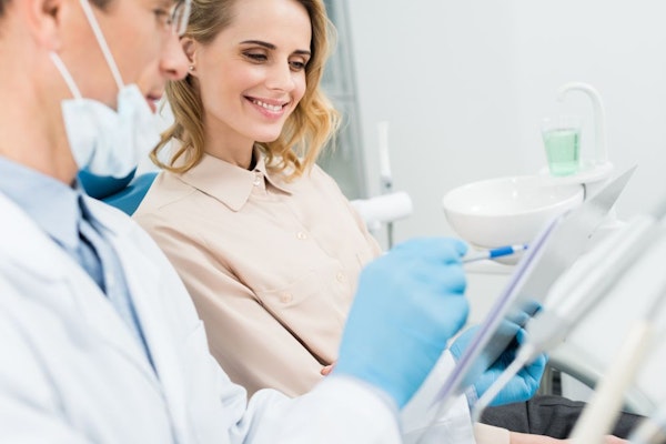 Smiling patient talking to dentist