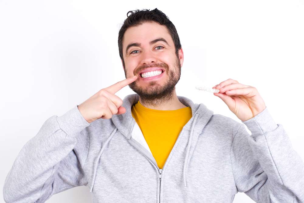 Invisalign patient pointing to his teeth