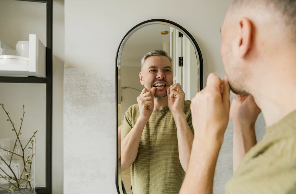 man flossing his teeth
