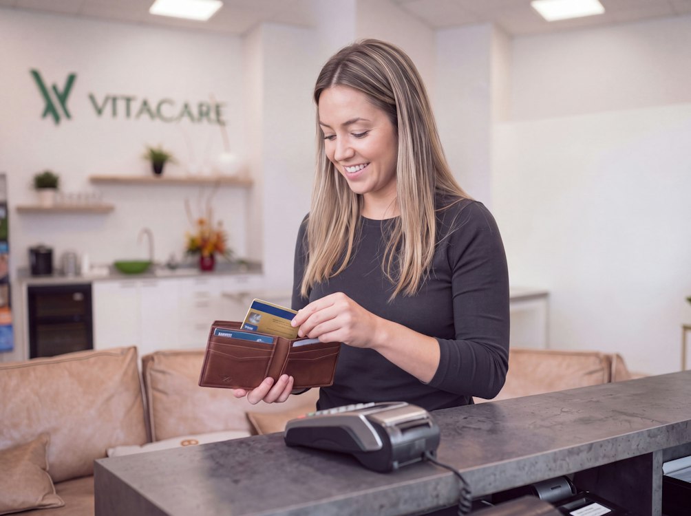 Photo of woman putting card away in her wallet at Vitacare office