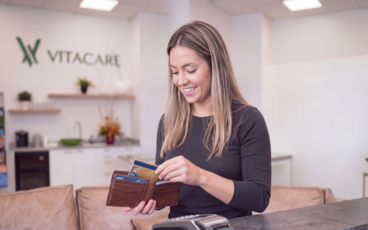 Photo of woman putting card away in her wallet at Vitacare office