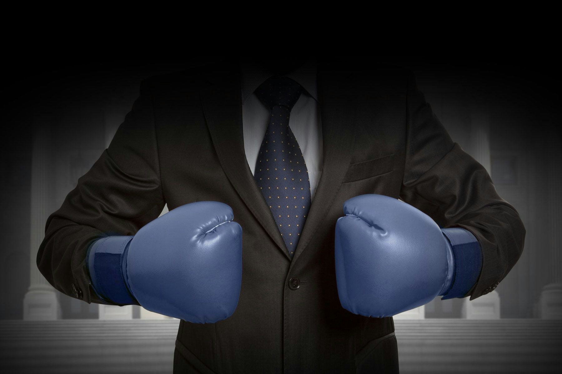 Businessman wearing boxing gloves and preparing for a legal battle