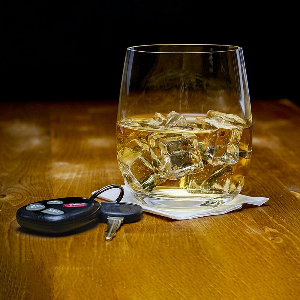 Whiskey, handcuffs, and car keys on jail intake form