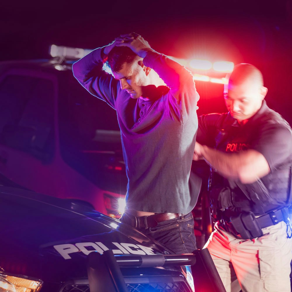 Police officer arresting man over drug charges