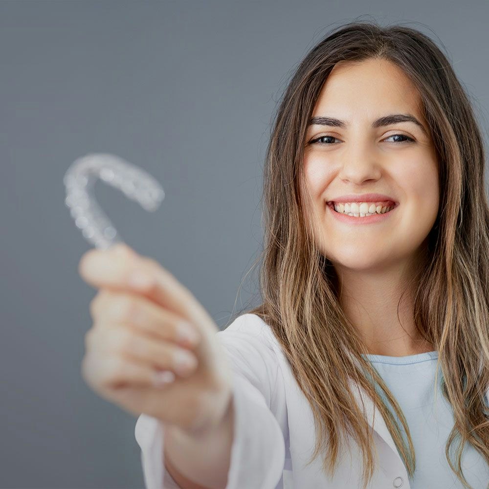Woman holding clear aligner