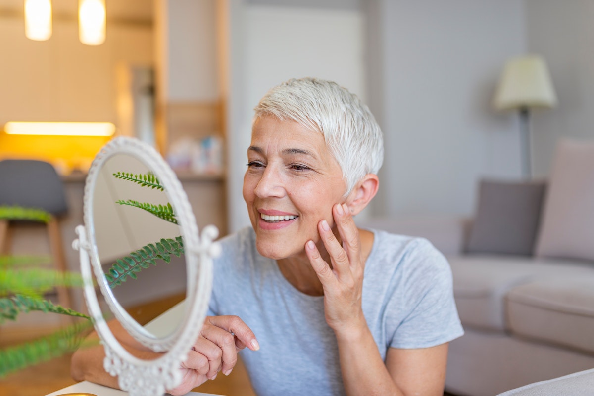 Mature woman admiring her smile in the mirror