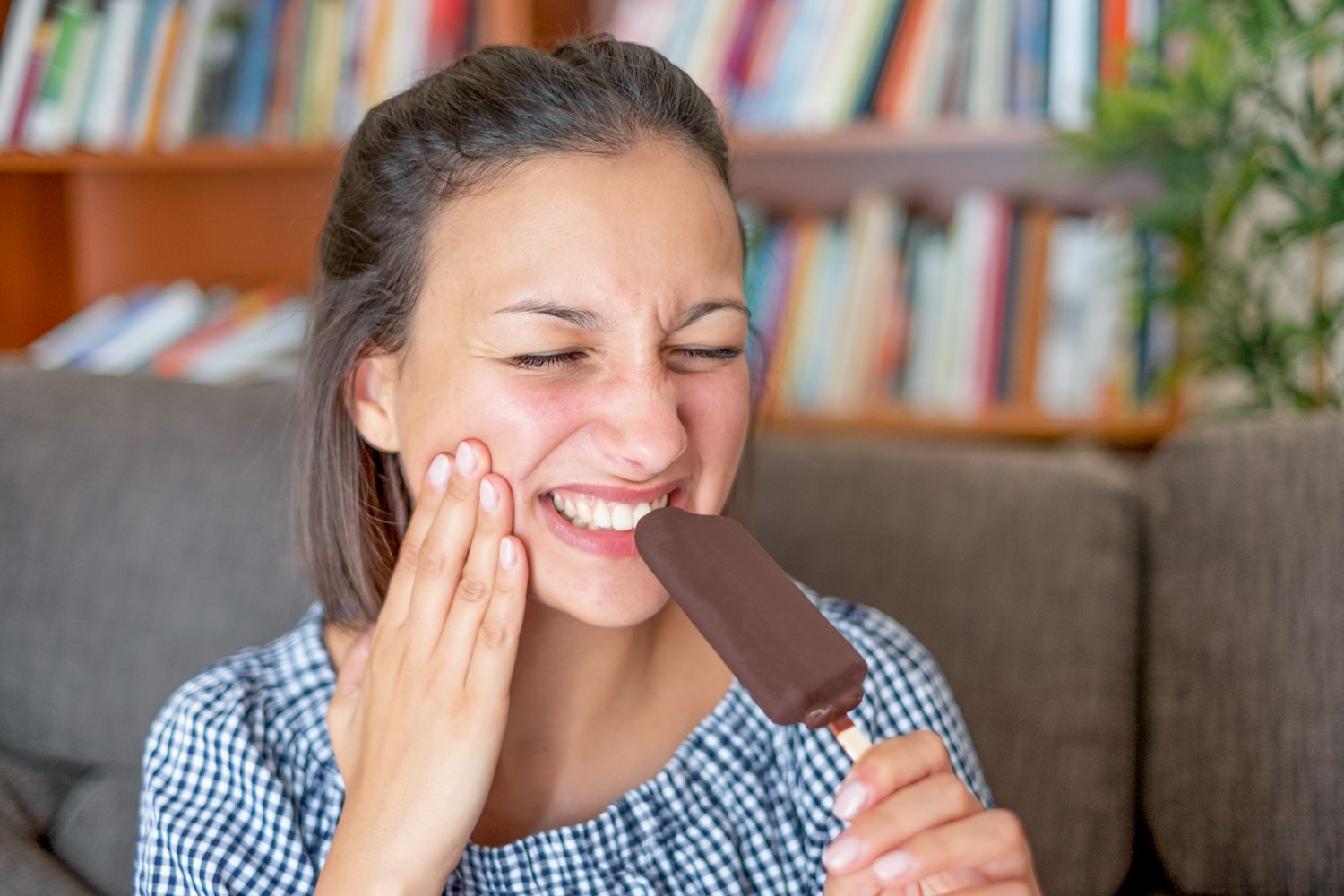 Woman in dental pain while eating ice cream