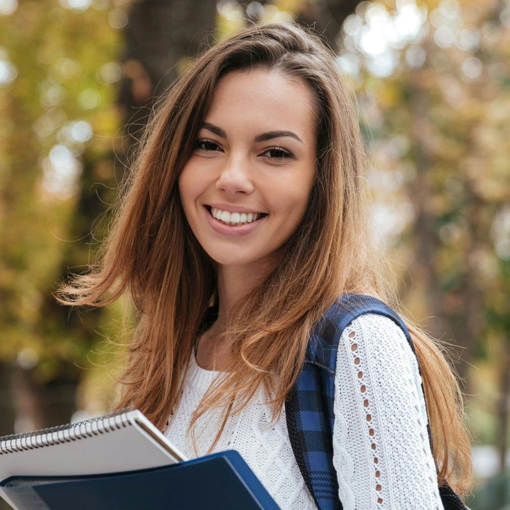 Young college student smiling a notebook