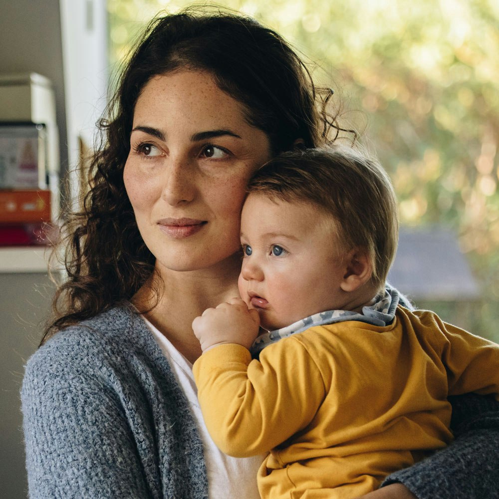Mother holding baby in kitchen