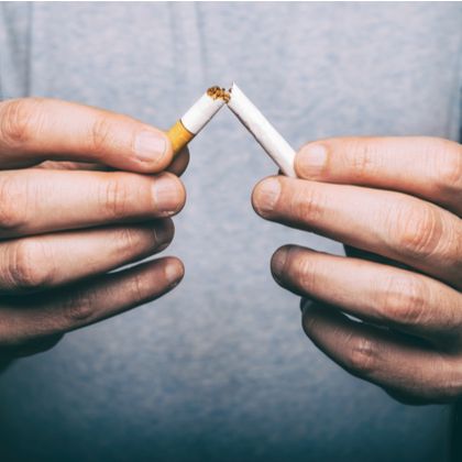 A man breaking a cigarette