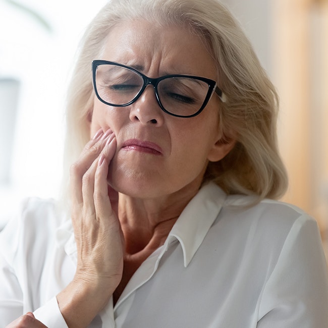 Older woman clutching jaw