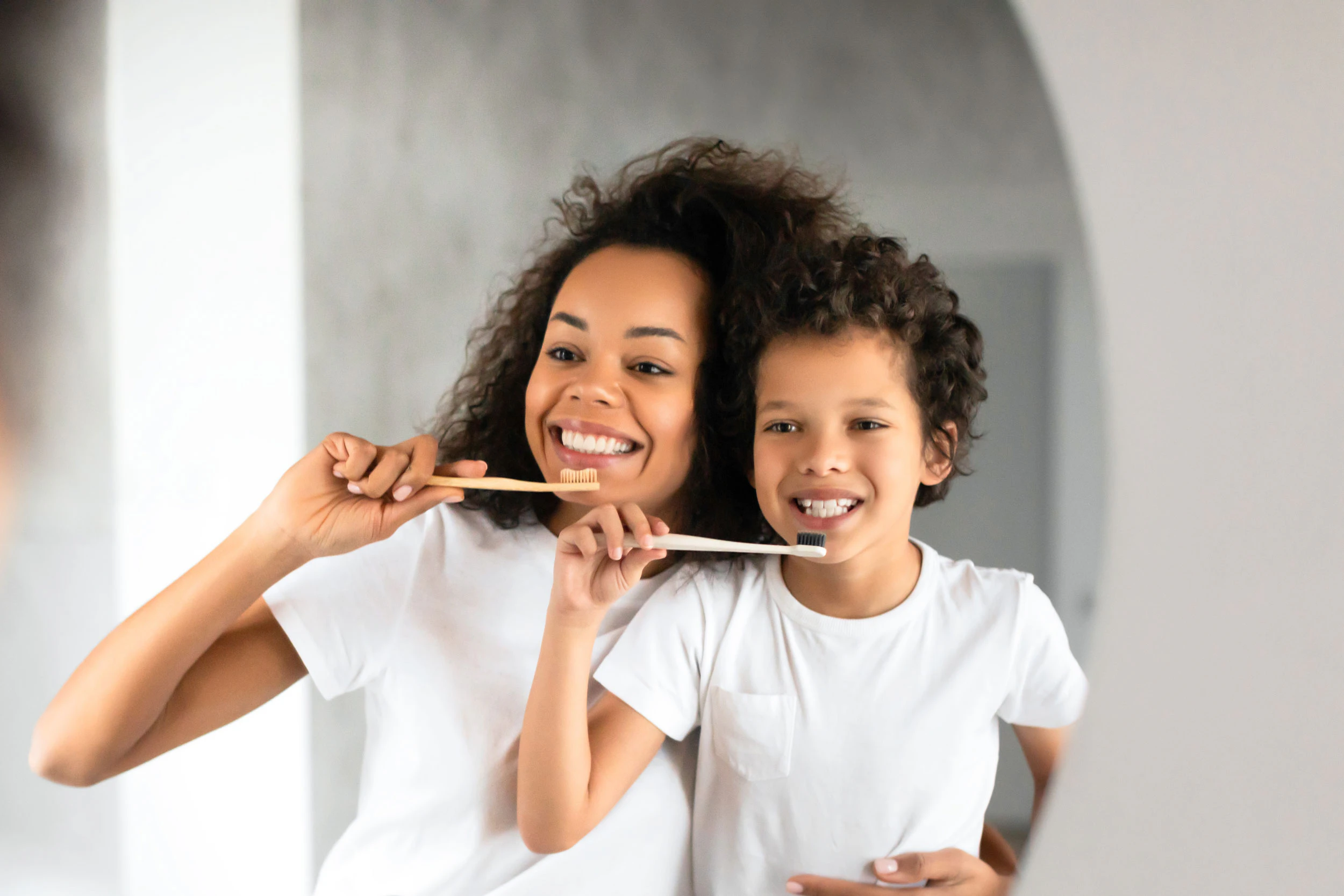 Mother and son brushing their teeth together