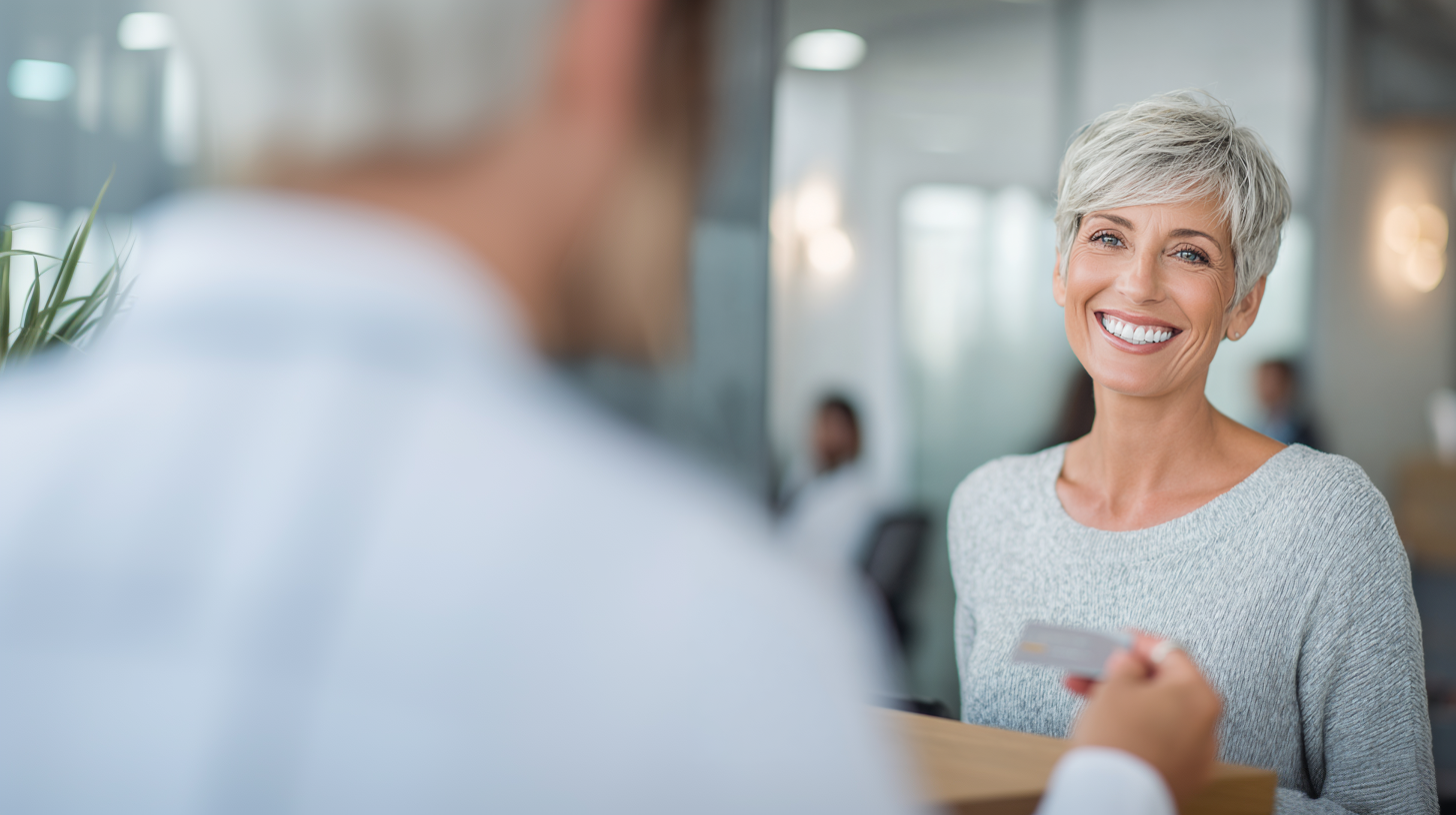 Woman smiling while speaking with someone handing her a card