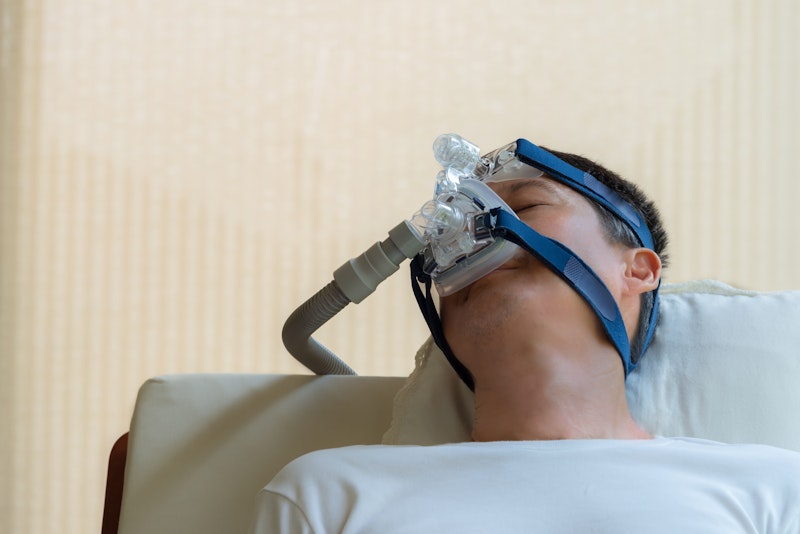 Man sleeping while wearing a CPAP machine