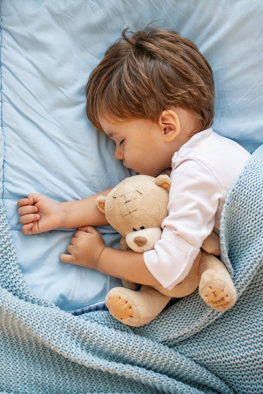 Boy sleeping with teddy bear