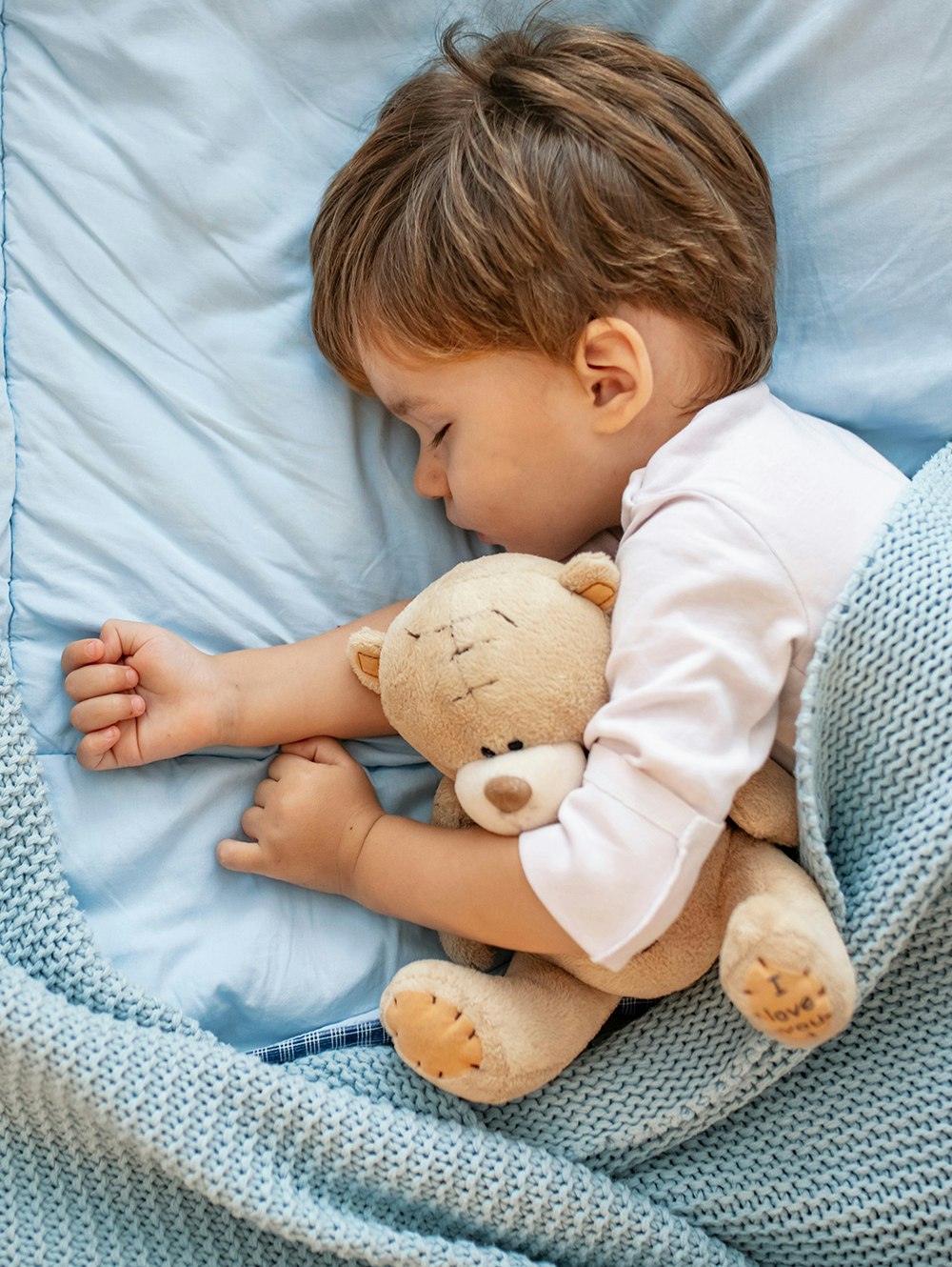 Boy sleeping with teddy bear