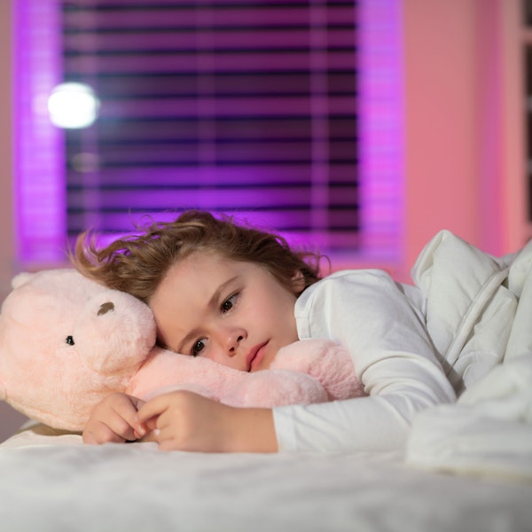 Young girl in bed with a teddy bear