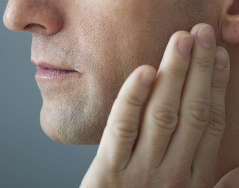 man with hand on his jaw