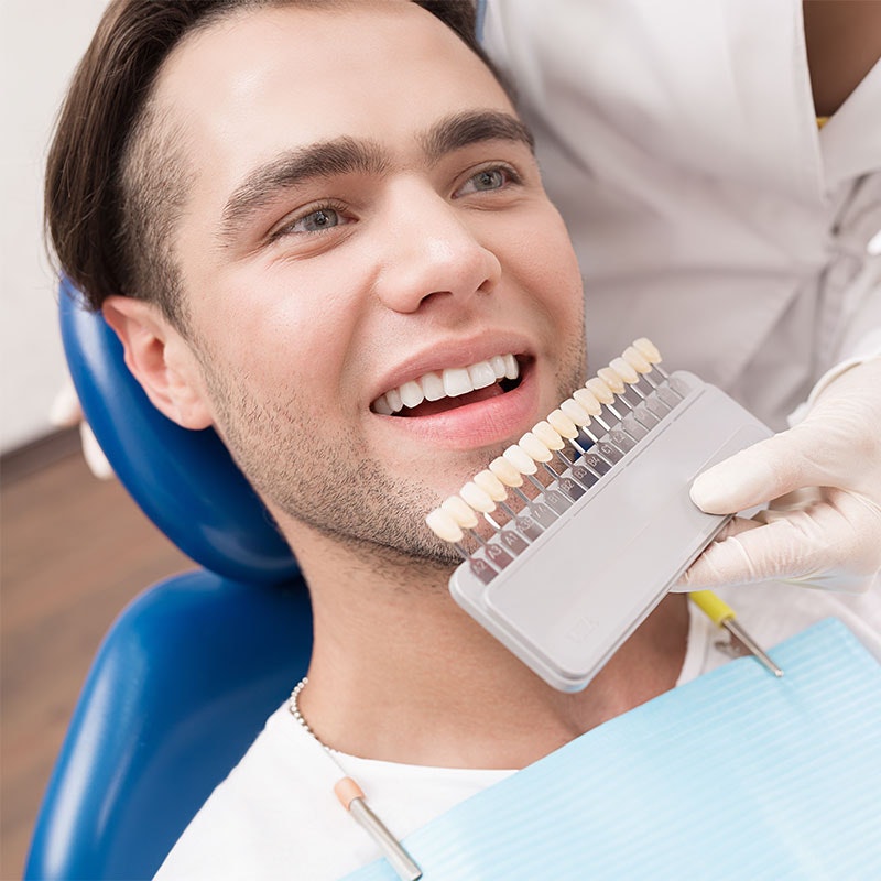 Young man being shade matched for veneers