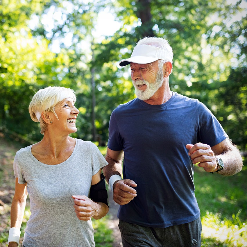 Older couple power walking outside