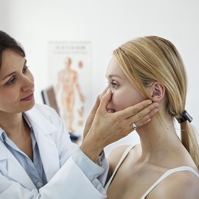 Doctor looking at patient's face and sinus area