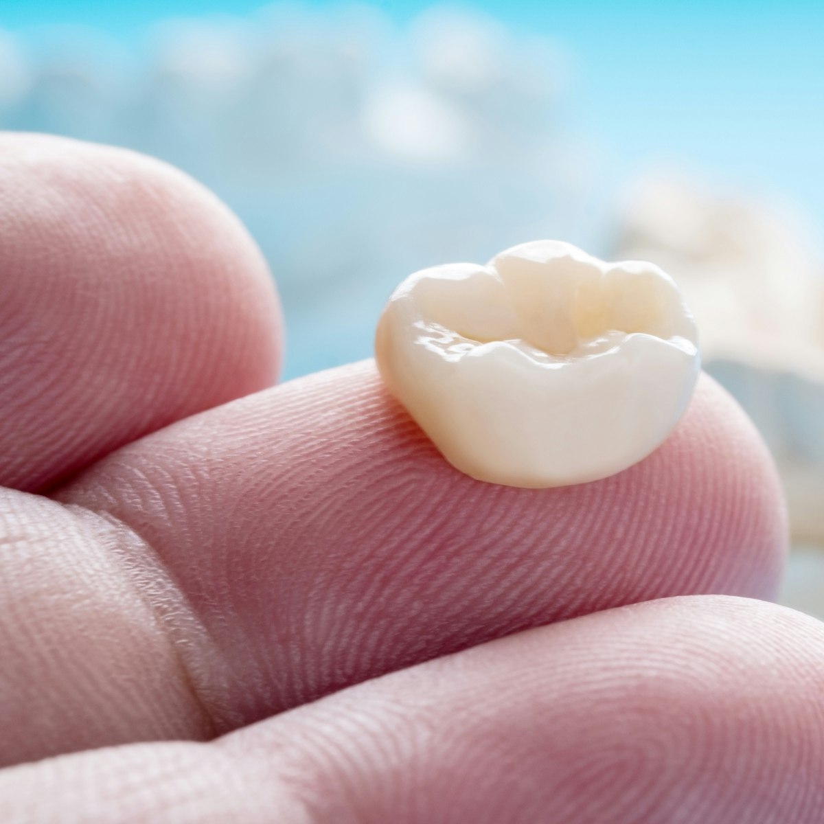 Dental crown on fingertip