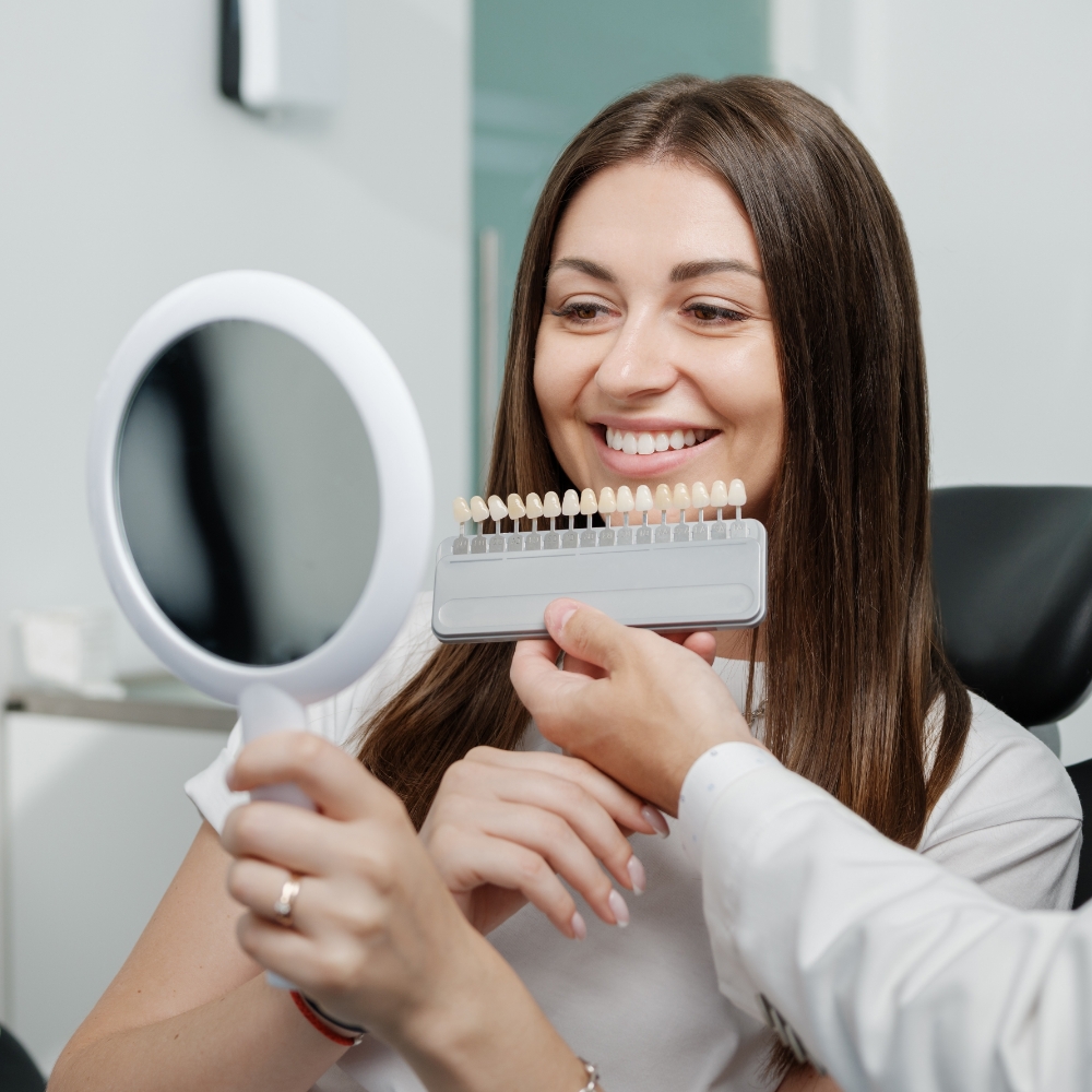 Woman looking at veneers in mirror