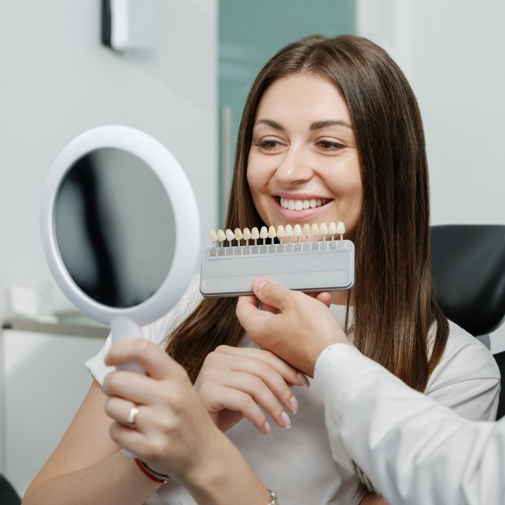 Woman looking at veneers in mirror