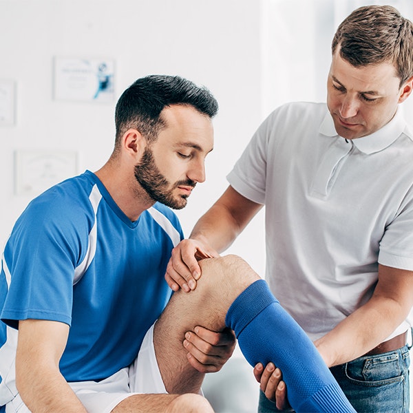 Doctor examining an athlete's knee