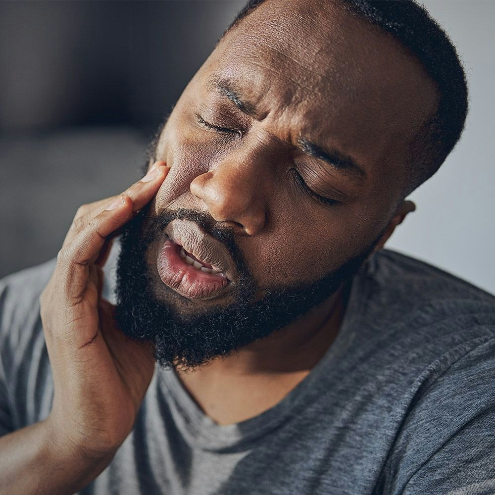 Man clutching jaw in pain