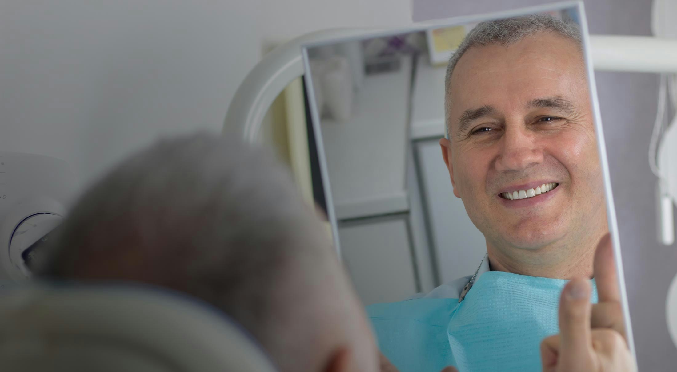 Male patient looking in the mirror and smiling