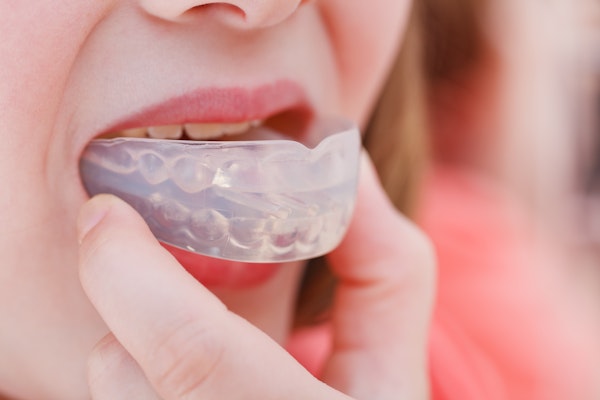 Smiling woman putting in mouthguard