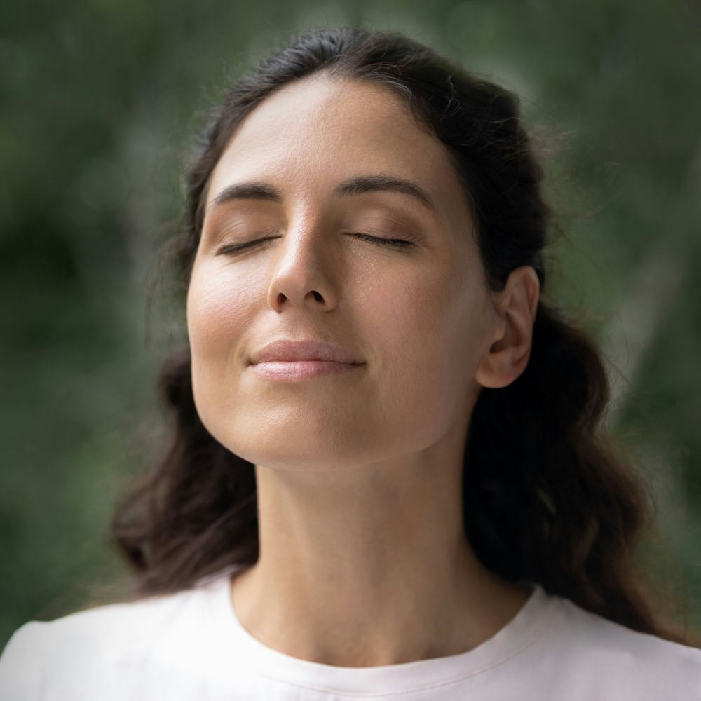 Woman relaxed with eyes closed outdoors
