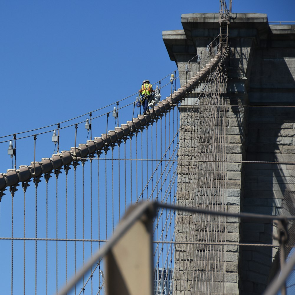 Construction worker walking up the Brooklyn bridge