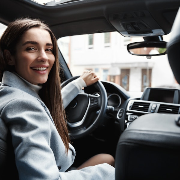 Female driver smiling back at passenger