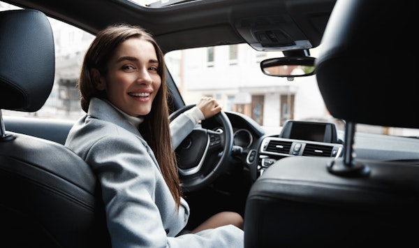 Female driver smiling back at passenger