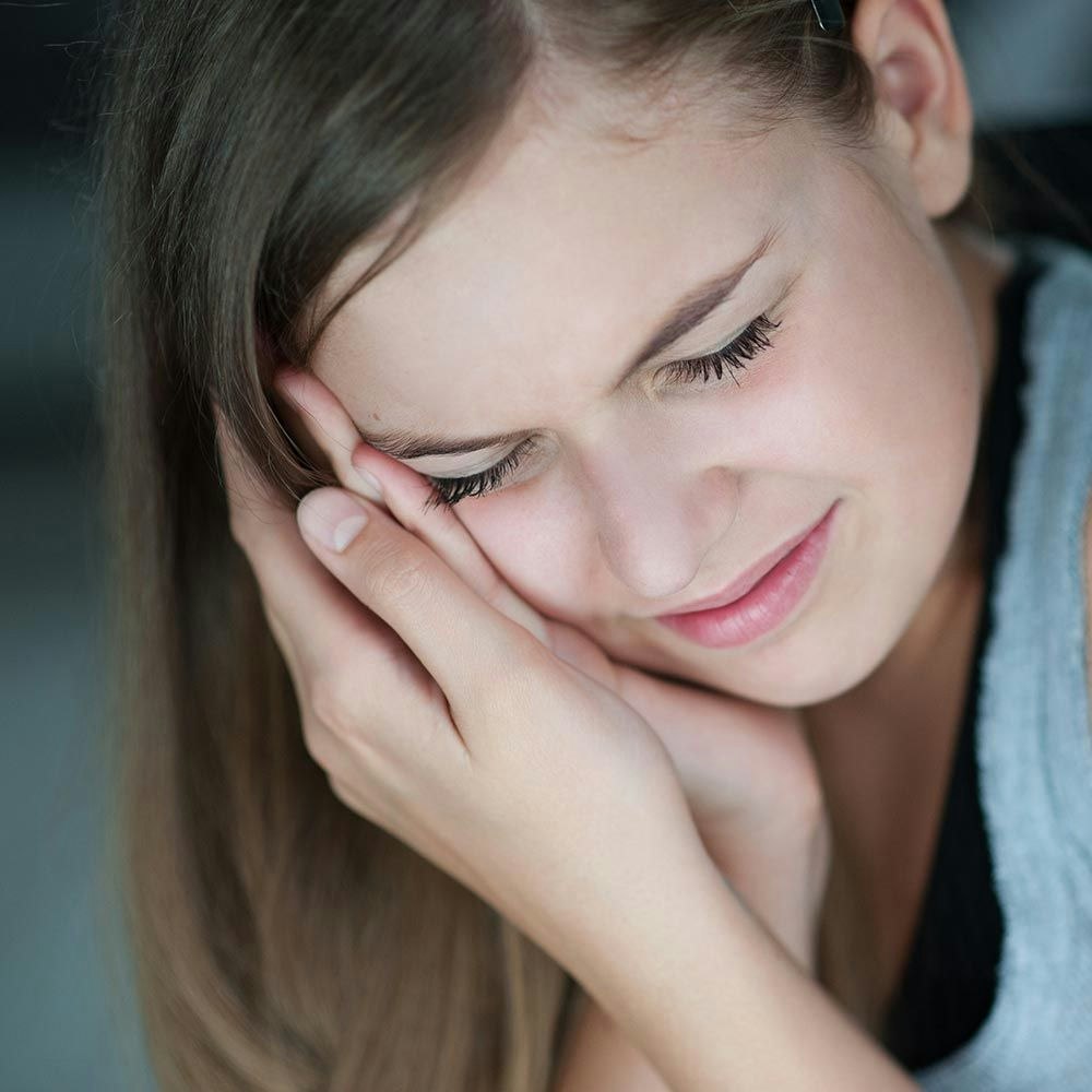Young girl holding jaw in pain
