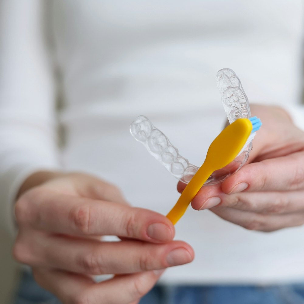 Orthodontic patient gently brushing aligner