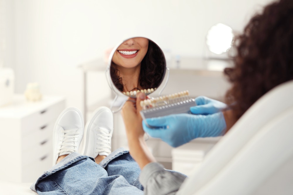 Woman looking at veneer shades at the dentist